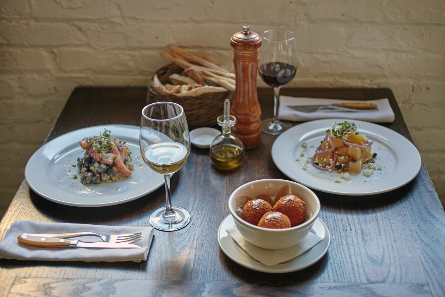 two plates of yummy food served with wine